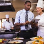 How To Create a Restaurant Website: The Essential Steps Male manager and female chef using digital tablet in kitchen at hotel
