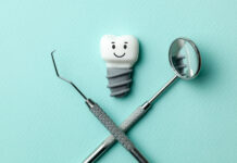 White teeth implants are smiling on green mint background and de
